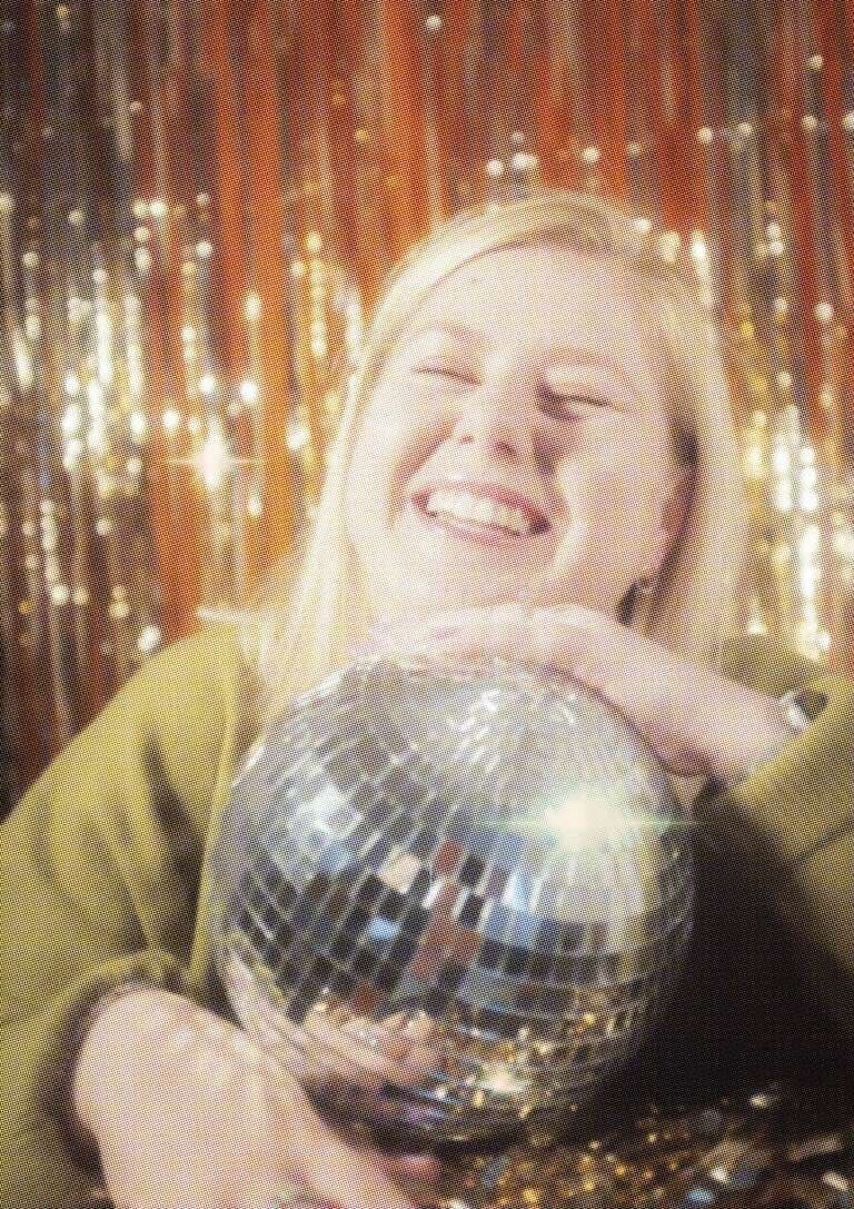 Fun professional headshot of Ashleigh holding a disco mirror ball.