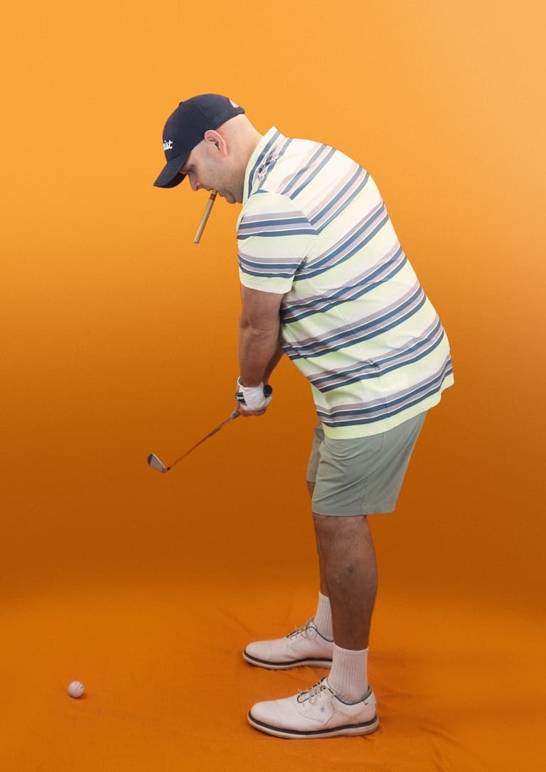 Fun headshot of Ian Bridgestock (Geek Designs) dressed as a golfer, swinging a club with a cigar in his mouth.