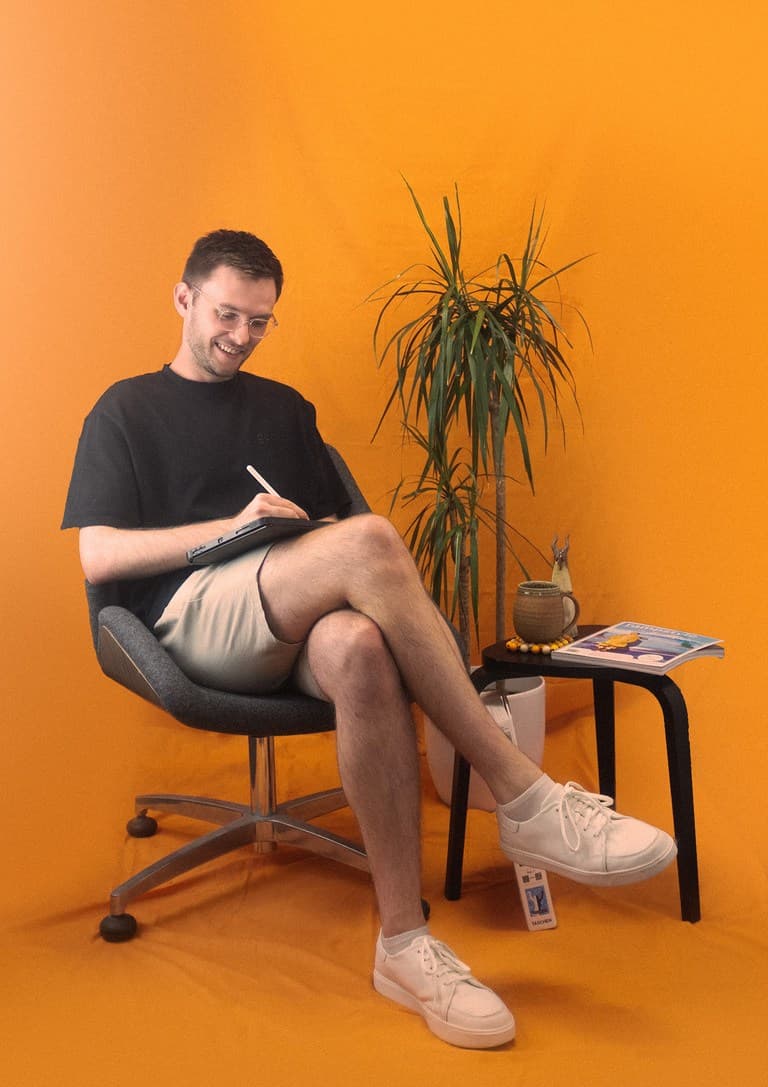 Fun headshot of Joe the designer sitting and sketching a concept on an iPad.
