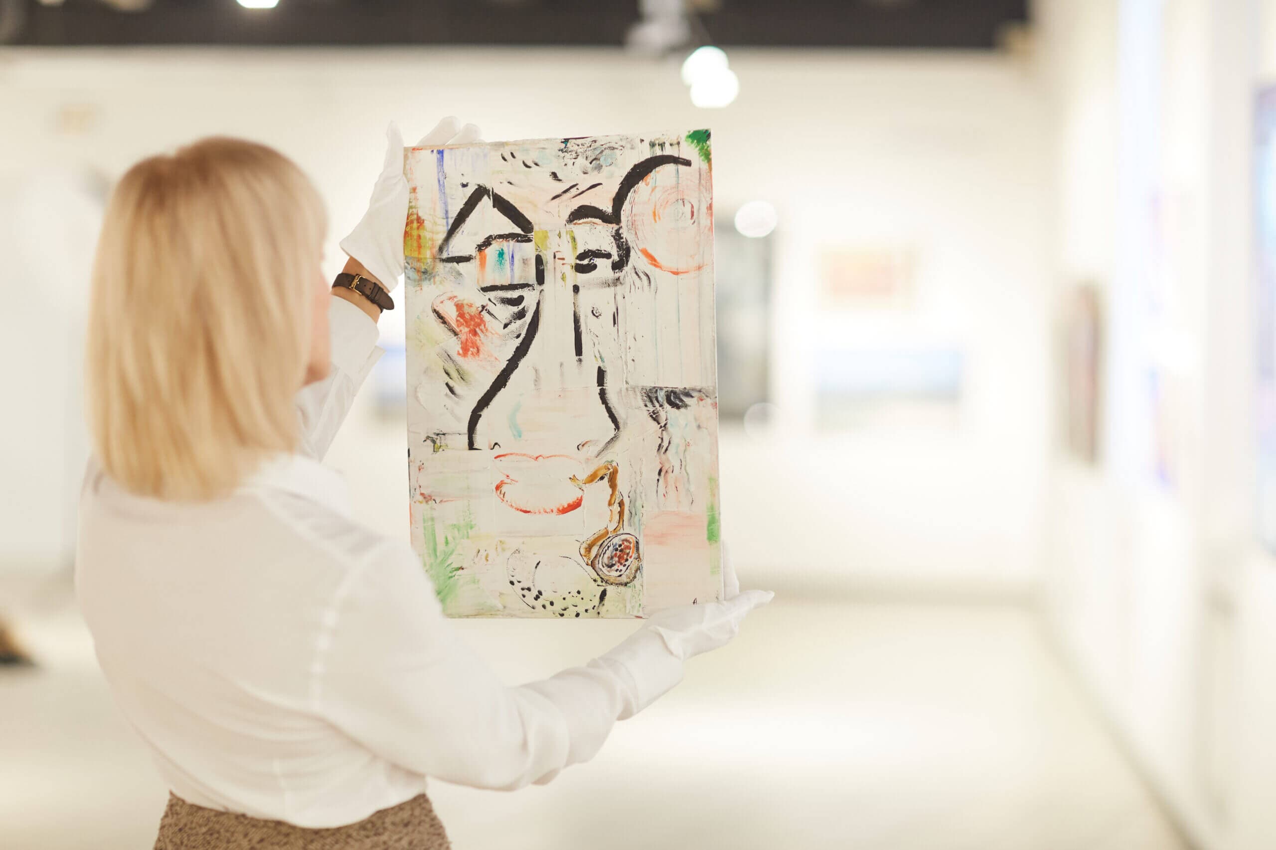 woman holding abstract painting in art gallery